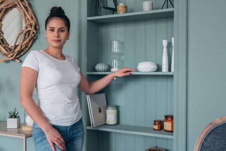 Beautiful brunette in white t-shirt and jeans in the Studio. Mock up for fashion designの写真素材