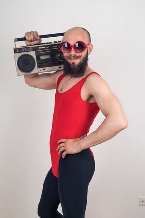 A man with a funny mustache in sunglasses posing on a white background. Party in retro style, the idea for the costume.の写真素材