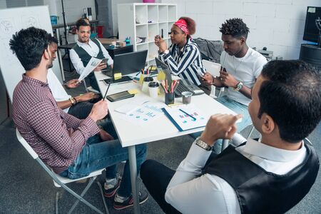 A group of promising businessmen are discussing the growth of profits on the example of graphsの写真素材