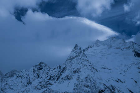 beautiful mountain slopes with snow at sunsetの写真素材