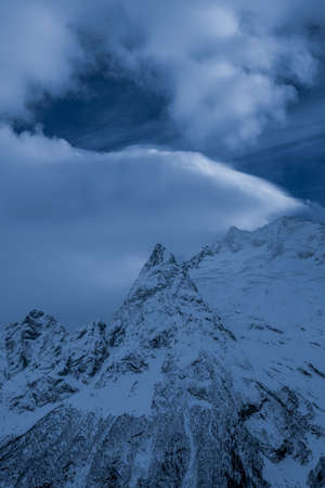 beautiful mountain slopes with snow at sunsetの写真素材