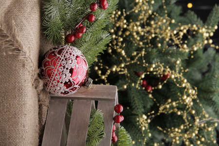 Christmas toys on a green Christmas tree with flashlightsの写真素材