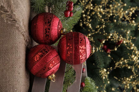 Christmas toys on a green Christmas tree with flashlightsの写真素材