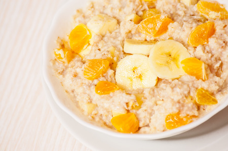 Bowl of oats porridge with banana and tangerineの写真素材