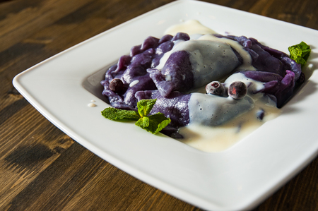 Dumplings with blueberries and cream. on a wooden backgroundの写真素材