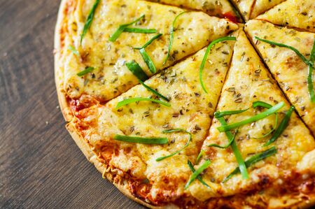 sliced Pizza Margherita or Margarita with Mozzarella cheese. Italian pizza on wooden background