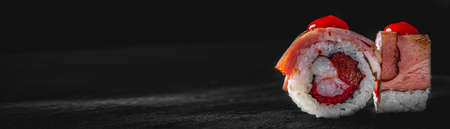 sushi roll with fish and rice on black wooden table backgroundの写真素材