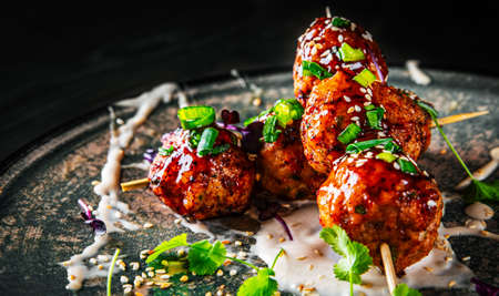 deep fried meatballs in plate on black wooden table backgroundの写真素材