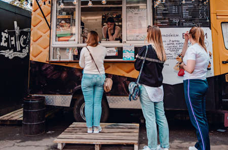 Minsk, Belarus - May 16, 2021: crowd of people buy meals from food truck. street food.のeditorial素材
