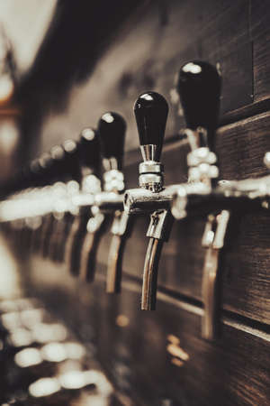 many beer taps in bar or pub. tap roomの写真素材