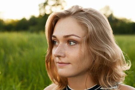 Close-up image of a beutiful girl isolated over green background looking asideの写真素材