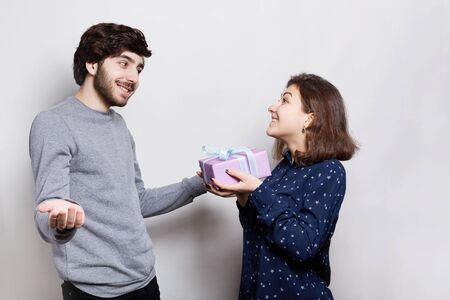 A surprised bearded guy being pleased to receive present from her girlfriend. Love, relationship,...