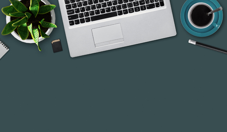 Office desktop with notebook, flash drive, mug of coffee, pencil, flower and blank sheet. Top view of office table with electronic gadget and stationary for work. Work, technology and business conceptの写真素材