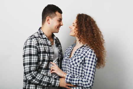 People, love and relationship concept. Lovely couple look at each other, feel support, have truthful feelings, embrace and going to kiss, isolated over white background. Curly female and her boyfriendの写真素材