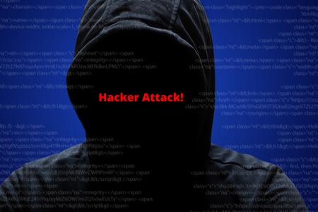 Hacker attack concept. Unrecognizable faceless mysterious male hacker in black hoodie poses against...