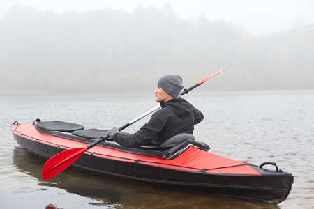 Side view of man kayaking on river in cold autumn cloudy day, kayaking, sports and recreation, male...
