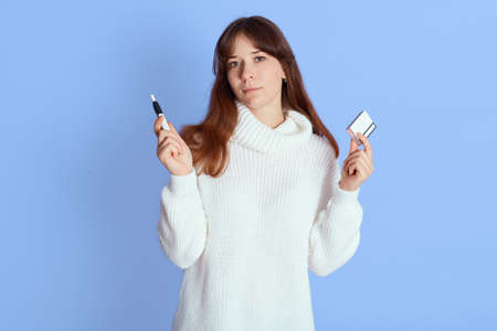 Young dark haired woman holding e-cigarette and sticks in her hands, lady with electronic cigarette,...