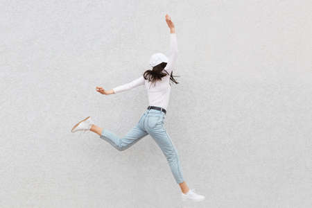 Full length photo of running in air amazing beautiful lady, raised up her hands, wearing casual...