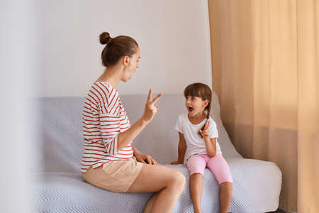 Portrait of female professional speech therapist working with little girl, having language lesson...