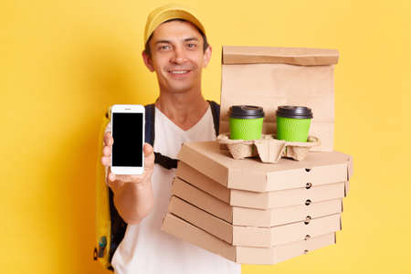 Indoor shot of happy kind man courier with thermo backpack in white T-shirt and cap isolated over...