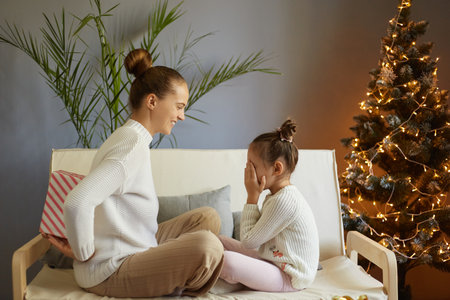 Happy family sharing joy with each other on Christmas. Daughter receives gifts from her loving...