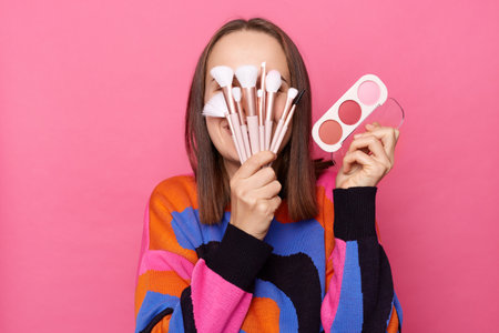 Photo of anonymous funny woman with dark straight hair wearing jumper standing isolated over pink...