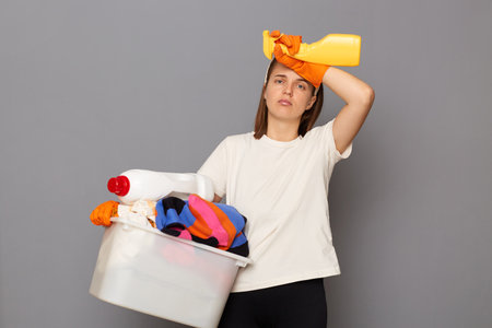 Housewife takes care of clothing. domestic appliances aid in housework. Tired exhaused woman wearing...