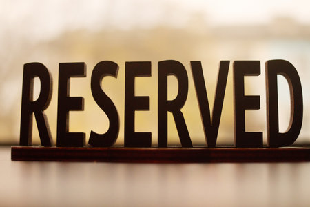 Reserved inscription label on blurred beige background.