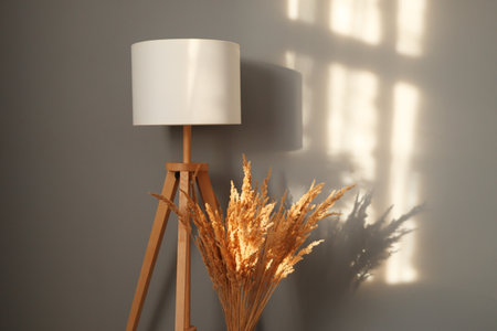 Beautiful interior with design dried flowers and lamp against gray wall with sunlight stylish decoration in modern living roomの写真素材