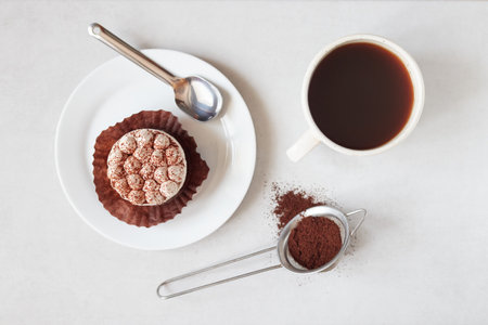 Cup of coffee and chocolate cake on white background, top view