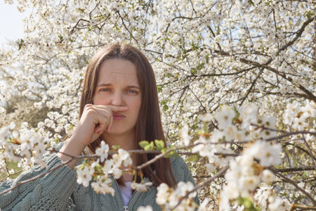 Portrait of a beautiful young woman in the spring blooming gardenの写真素材