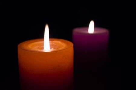 Two candles burning in the darkの写真素材