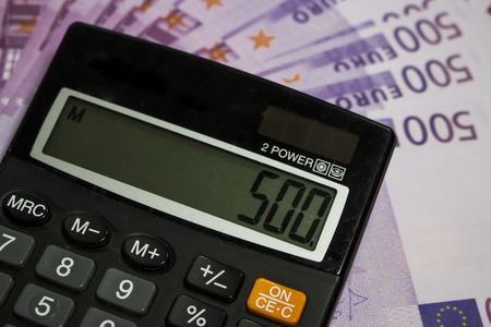Calculator on the table with a lot of moneyの写真素材