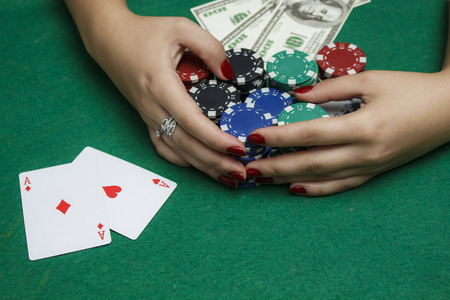 The girl at the poker table is holding chips