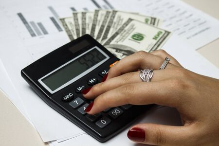 Accountant counts money with a calculatorの写真素材