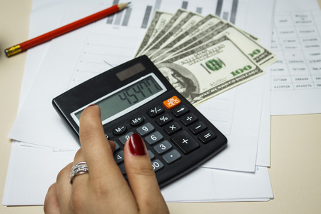 Accountant counts money with a calculatorの写真素材