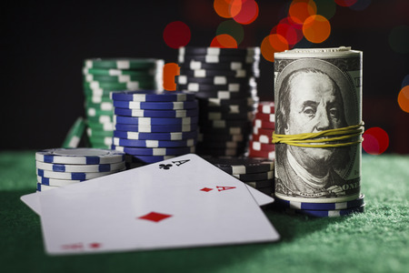 Poker chips, dollars and a pair of acesの写真素材
