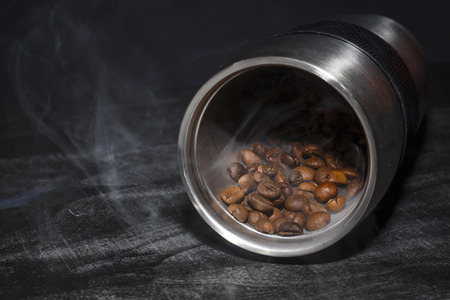 Roasted coffee beans are poured from a cupの写真素材