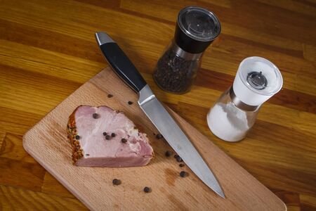 Slice of smoked ham on a cutting board with knife