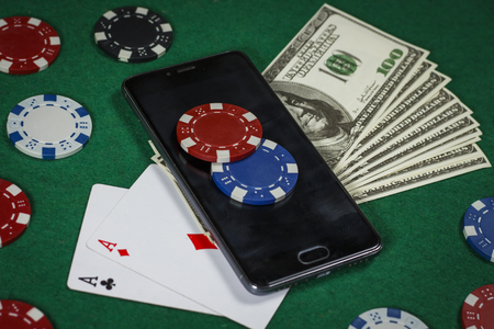 Poker chips, phone and cards on the green tableの写真素材