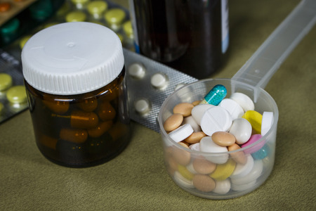 Pile of pills in a plastic measuring spoonの写真素材