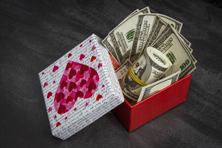 Pile of dollars in a red gift boxの写真素材