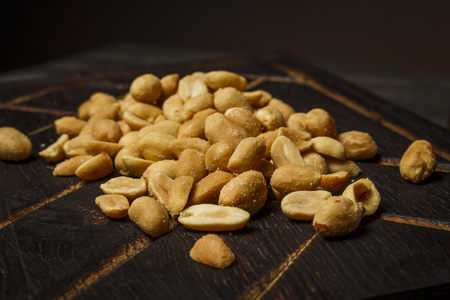 Peanuts on a dark wooden boardの写真素材