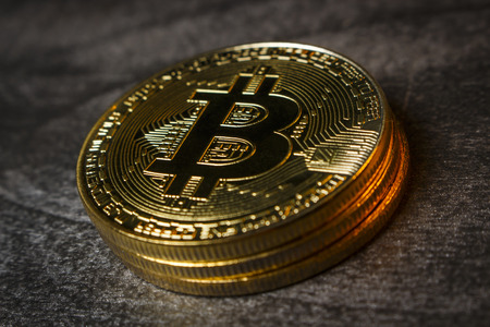 Three golden coins in the form of bitcoins close upの写真素材