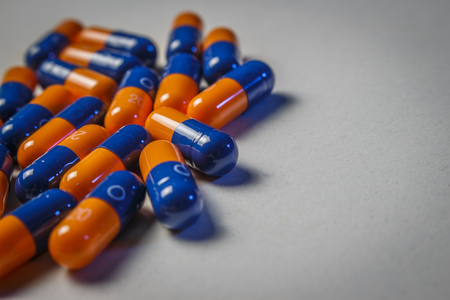 Blue-orange capsules on a white doctor's tableの写真素材