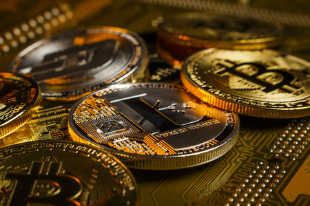 Gold and silver coins cryptocurrency lie on the motherboardの写真素材