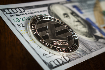 Litecoin coin on the hundred dollar billの写真素材