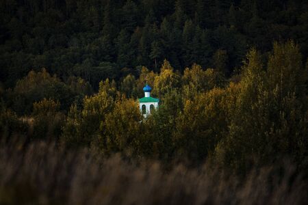 Pskov region, the village of Mali. Through the fall foliage you can see the monastery bell towerの写真素材