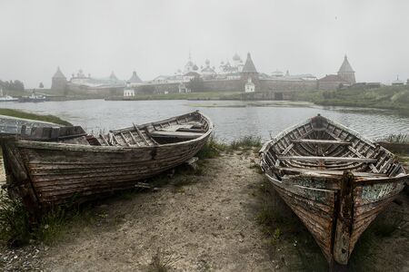 Two old boats in the foreground, behind - Well-being Bay and Solovetsky Monasteryの写真素材
