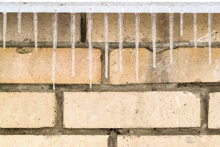 Background with bricks and icicles. Background with empty space fot text or image.の写真素材